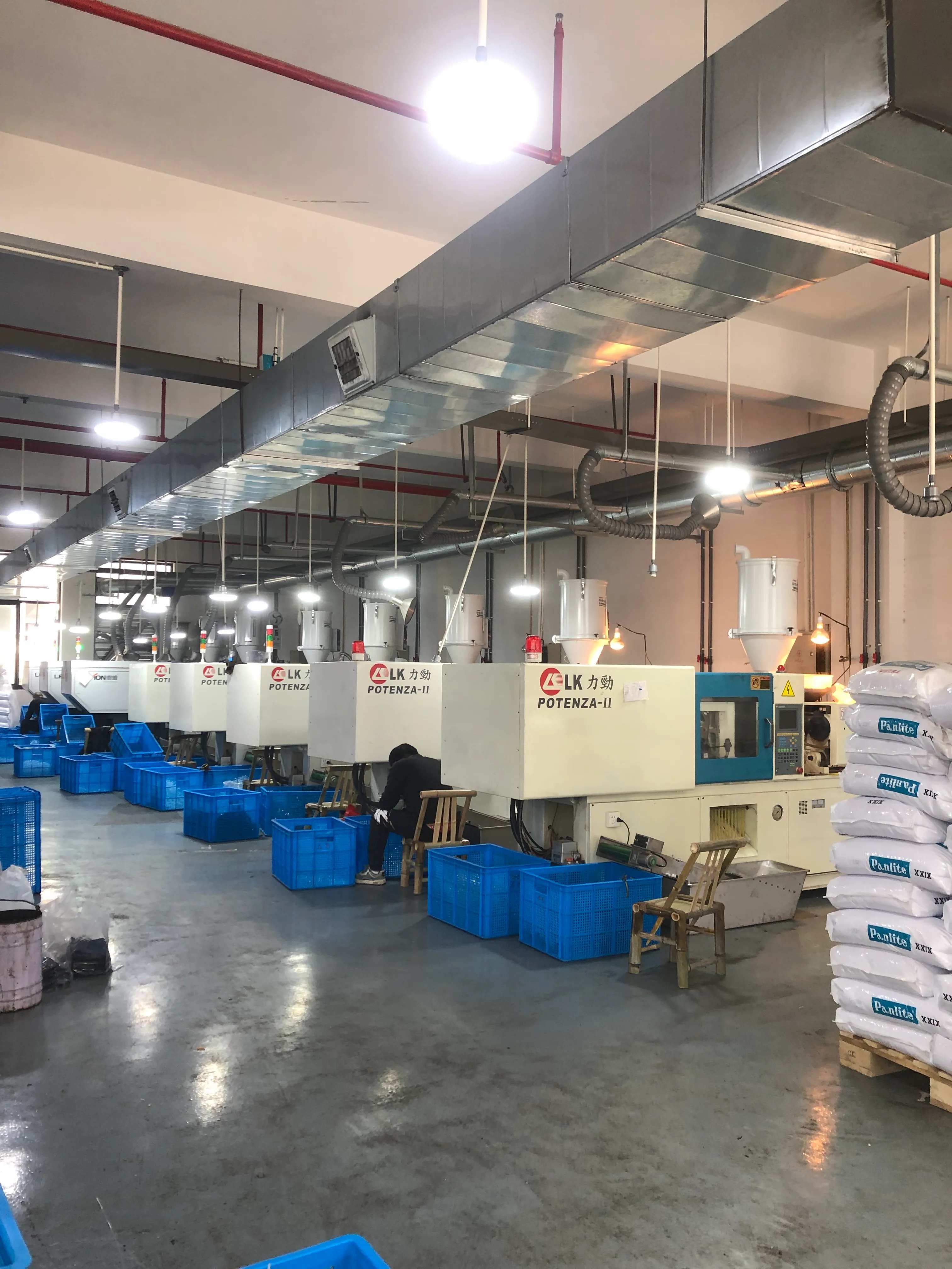 Injection molding workshop at the Three Hippos factory with a row of LK Potenza-II machines producing PC and TR90 eyewear frames